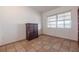 Minimal bedroom features a neutral tile floor, large windows, and a small woven dresser at 415 Manor Dr, Bartow, FL 33830