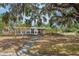 Charming one-story brick home featuring an inviting front yard with mature trees and a sidewalk at 415 Manor Dr, Bartow, FL 33830
