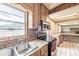 Well-lit kitchen with stainless steel sink and wood cabinets offers ample workspace at 415 Manor Dr, Bartow, FL 33830