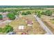 Overhead shot of a mobile home situated on a spacious lot with other buildings, surrounded by trees and greenery at 4207 Ollie Rd, Lakeland, FL 33810