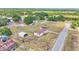 Scenic aerial view of a mobile home on a large lot surrounded by trees, with extra buildings and open space at 4207 Ollie Rd, Lakeland, FL 33810