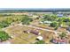 Aerial view of a property featuring a mobile home with several outbuildings and a expansive yard under clear skies at 4207 Ollie Rd, Lakeland, FL 33810
