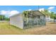 An empty metal carport with chain link fencing with some overgrown vines on a sunny day at 4207 Ollie Rd, Lakeland, FL 33810