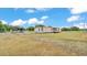 Exterior view of a single story home with two sheds, carport, and an empty lawn at 4207 Ollie Rd, Lakeland, FL 33810