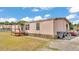 A side exterior view of the single story home showing the deck, siding, and lawn at 4207 Ollie Rd, Lakeland, FL 33810