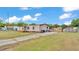Exterior view of single-story home, yard, and sheds on a sunny day with a blue sky at 4207 Ollie Rd, Lakeland, FL 33810