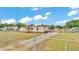 A mobile home with a fenced yard and outbuildings sits under a bright sky in this exterior shot at 4207 Ollie Rd, Lakeland, FL 33810