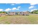 Exterior shot of a single story home with siding on a large lot with grass and two windows at 4207 Ollie Rd, Lakeland, FL 33810