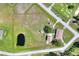 Aerial view of property, outlined in yellow, featuring a pond, surrounded by grassy fields and a home at 4404 Musket Dr, Lakeland, FL 33810
