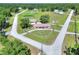 Aerial view of house with metal roof, circular driveway, lush trees, and corner lot at 4404 Musket Dr, Lakeland, FL 33810