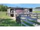 Rustic horse barn with a weathered fence, shaded enclosure, and a friendly horse peering out at 4404 Musket Dr, Lakeland, FL 33810