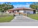 Ranch-style home with a metal roof, fenced yard, and gated entrance at 4404 Musket Dr, Lakeland, FL 33810
