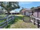 Exterior view of the home showcasing a large barn, horse shelter, wood fence, and large open green space at 4404 Musket Dr, Lakeland, FL 33810