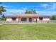 Inviting single-story home with metal roof, brick accents, an American flag, and a manicured lawn at 4404 Musket Dr, Lakeland, FL 33810