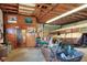 Spacious garage featuring a trailer, tools, storage, wood paneled walls, and an unfinished wood beam ceiling at 4404 Musket Dr, Lakeland, FL 33810