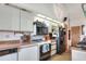 Galley kitchen with white cabinets, wood countertops, and black appliances at 4404 Musket Dr, Lakeland, FL 33810