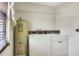 Efficient laundry room features white appliances and shelving for organized storage and convenience at 4404 Musket Dr, Lakeland, FL 33810