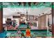 View of the open-concept living room from the bar, featuring a pool table and stone fireplace at 4404 Musket Dr, Lakeland, FL 33810