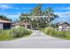 Gated property entrance with a driveway, flanked by lush greenery, leading to multiple buildings at 4404 Musket Dr, Lakeland, FL 33810