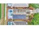 Aerial view of a house with solar panels, a screened pool, and well-maintained landscaping at 506 Henley Cir, Davenport, FL 33896