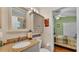 Bathroom vanity with a stone countertop, single sink, mirror and cabinet with a view of a bedroom at 506 Henley Cir, Davenport, FL 33896