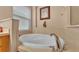 A soaking tub is encased in tile with a chrome faucet, a window, and art hanging on the wall at 506 Henley Cir, Davenport, FL 33896