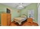 A bedroom with wood floors, a ceiling fan, dresser, nightstand, and a window with blinds at 506 Henley Cir, Davenport, FL 33896