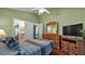 Spacious bedroom featuring wood floors, large windows, television, and modern furnishings at 506 Henley Cir, Davenport, FL 33896