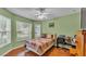 Comfortable bedroom with hardwood floors, bright windows, and a ceiling fan at 506 Henley Cir, Davenport, FL 33896