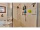 A tiled walk-in shower is supplied with a handheld shower head and lots of storage for toiletries at 506 Henley Cir, Davenport, FL 33896