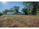 Vast backyard featuring a shed, lawn, and mature trees provides ample space for outdoor enjoyment and activities at 526 Marklen Loop, Polk City, FL 33868