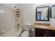 A cozy bathroom equipped with a shower-tub combo, granite vanity, and a decorative framed mirror at 526 Marklen Loop, Polk City, FL 33868