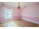 This bedroom features hardwood floors, a chandelier light fixture, and a window for natural light at 526 Marklen Loop, Polk City, FL 33868