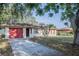 Charming single-story home with a red garage door, front lawn, and lovely landscaping at 526 Marklen Loop, Polk City, FL 33868