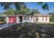Charming single-story home with a red garage door and a well-maintained front yard at 526 Marklen Loop, Polk City, FL 33868