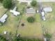 Aerial view of the property showing the house, a trampoline, surrounding trees, and adjacent residential area at 5339 Meadow Grove Trl, Lakeland, FL 33810