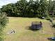 Large backyard features a fire pit and a trampoline surrounded by grassy lawn and mature trees for shade at 5339 Meadow Grove Trl, Lakeland, FL 33810