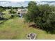 Spacious backyard features mature trees, a fire pit, and lawn area with distant views of nearby homes at 5339 Meadow Grove Trl, Lakeland, FL 33810