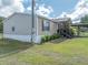 Exterior view of a cozy home, displaying the side yard and carport at 5339 Meadow Grove Trl, Lakeland, FL 33810