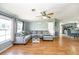 Living room with hardwood flooring, plush gray couch, and view of the kitchen and dining area at 5339 Meadow Grove Trl, Lakeland, FL 33810