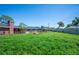Green backyard with landscaping, large trees and screened-in pool area behind a brick house at 5604 Stratford Ln, Lakeland, FL 33813