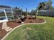 Landscaped backyard with a patio enclosure and mulched flowerbeds at 5604 Stratford Ln, Lakeland, FL 33813