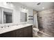 Bathroom featuring double sinks with a marble countertop and a tiled walk-in shower at 5604 Stratford Ln, Lakeland, FL 33813