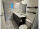 Bright bathroom with dual sinks, a gray vanity, marble countertops, and floating shelves at 5604 Stratford Ln, Lakeland, FL 33813