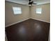 Bedroom with wood-look floors, a ceiling fan, and natural lighting through two windows at 5604 Stratford Ln, Lakeland, FL 33813