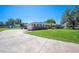 Charming brick ranch-style home with black shutters, a manicured lawn, and an extended driveway leading to the garage at 5604 Stratford Ln, Lakeland, FL 33813