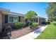 Well-maintained brick house showcasing manicured landscaping, a walkway, and a small palm tree adding curb appeal at 5604 Stratford Ln, Lakeland, FL 33813