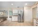 Bright kitchen featuring stainless steel refrigerator, granite countertops, and ample white cabinetry at 5604 Stratford Ln, Lakeland, FL 33813