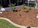 Garden area with roses and landscaping bordering the screened-in enclosure of the residence at 5604 Stratford Ln, Lakeland, FL 33813