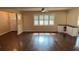 Bright living room with hardwood floors, ceiling fan, large window with shutters, and built-in bar at 5604 Stratford Ln, Lakeland, FL 33813